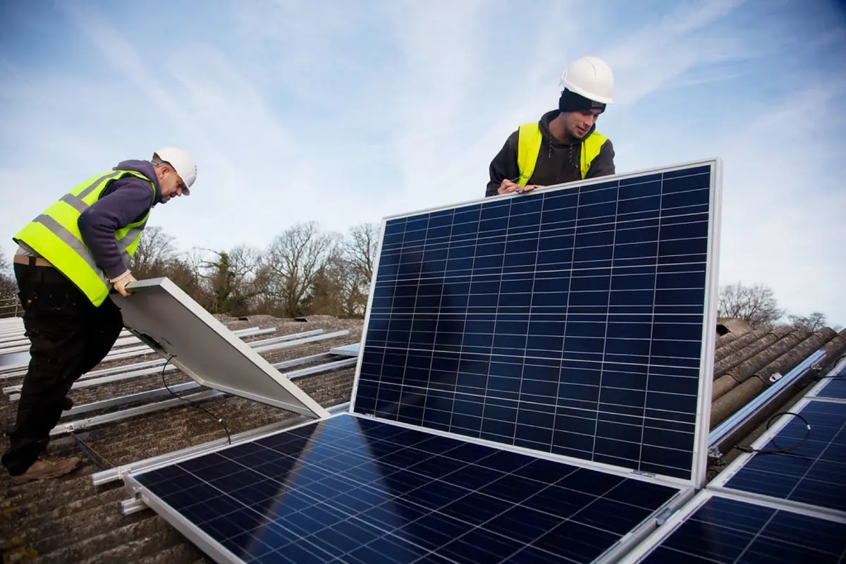 Installers fitting solar panels on a rooftop